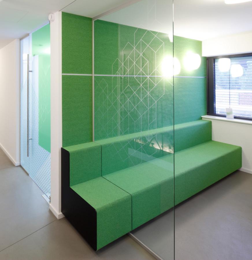 green seating and glass partition wall in a doctor's surgery
