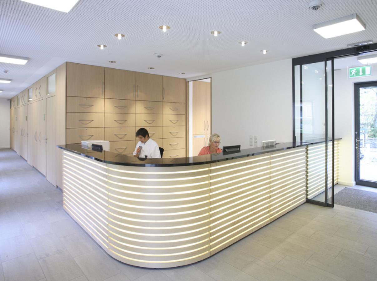 TPK-08, photo: Christoph Edelhoff reception desk with horizontal wooden slats and backlit joints
