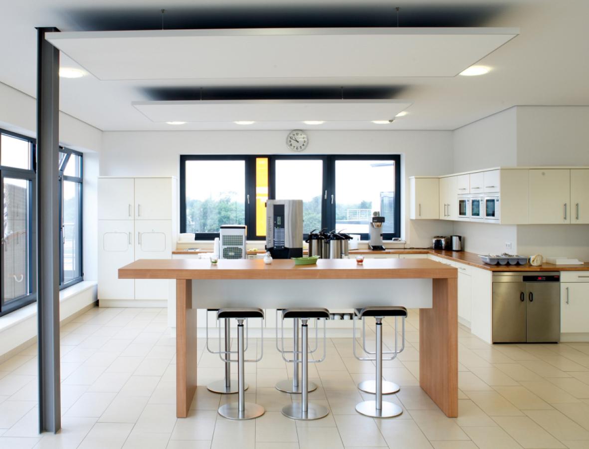 massiver Holztisch mit Barhockern in einer Kantine