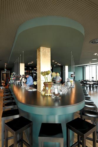 lange Treseninsel mit dunkler Thekenplatte und türkisfarbener Tresenfront und Baldachin im Restaurant Längengrad Kiel