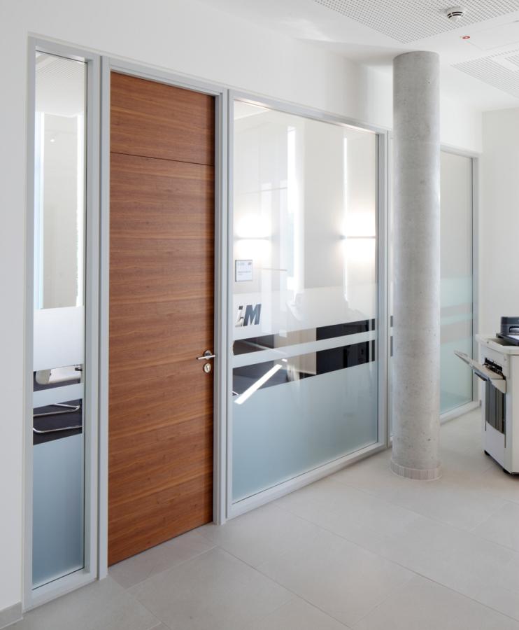 horizontal furnierte Holztür und Glastrennwände in einem Büro