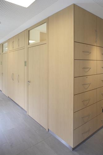 Wandverkleidung mit Tür und Schränken aus Holz