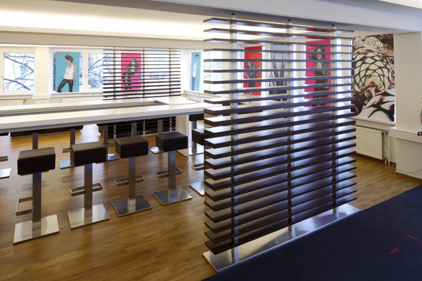 Lamellen-Trennwand aus dunklem Holz mit Edelstahlkonstruktion