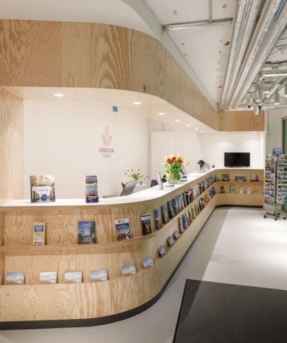 Information counter with curved front and canopy made of maritime pine in the Rathauspassage Hamburg